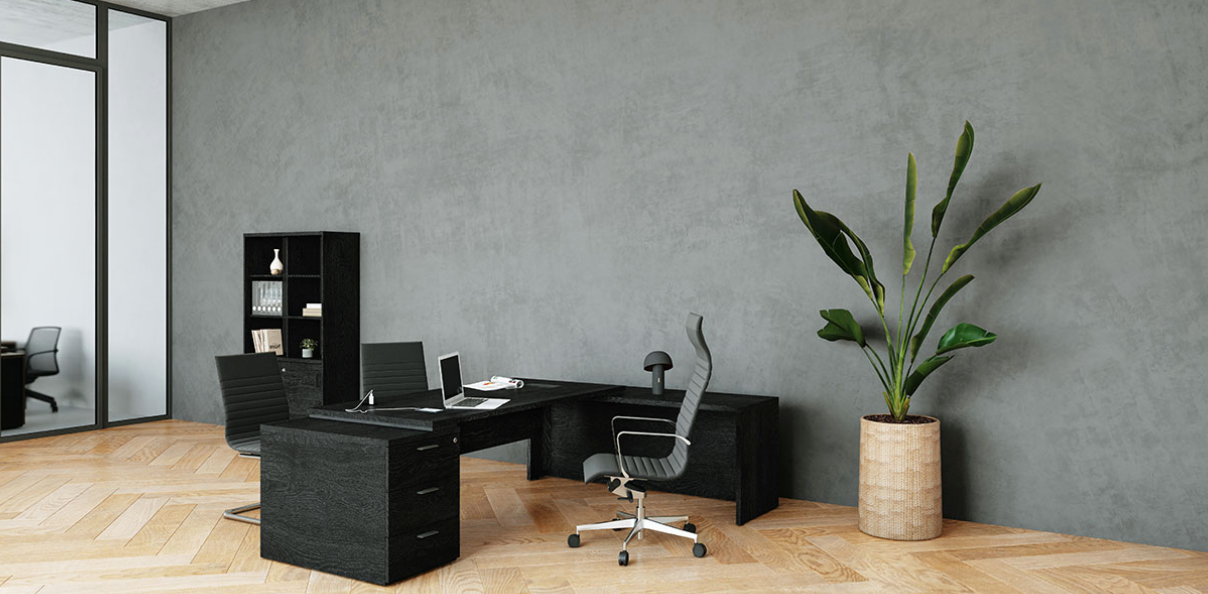 Vue d'ensemble d'un aménagement de bureau moderne avec le bureau de direction d'angle Kara en finition Bois Noir, son retour avec caisson et une armoire assortie